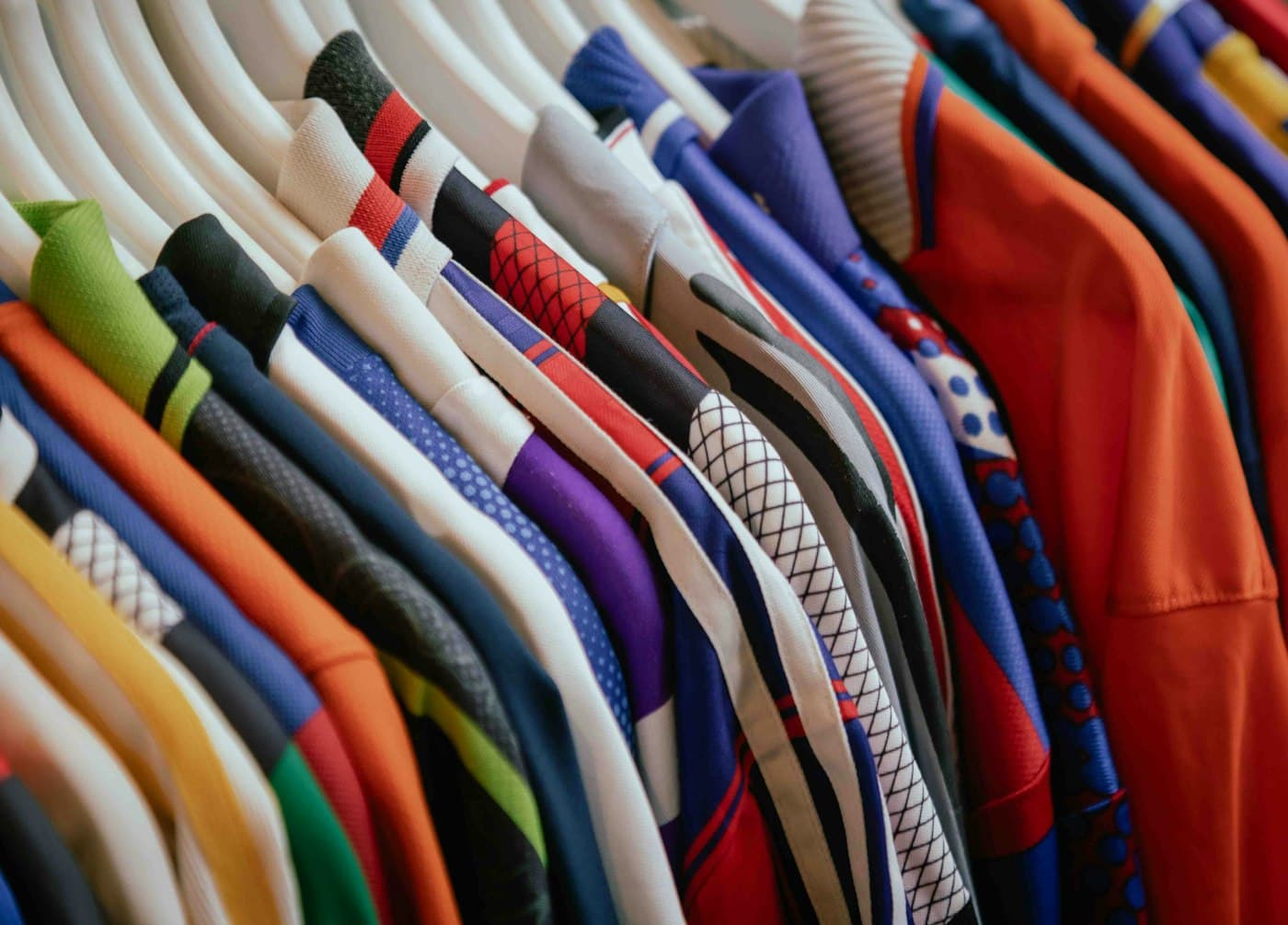 Rack of colourful team jerseys on hangers